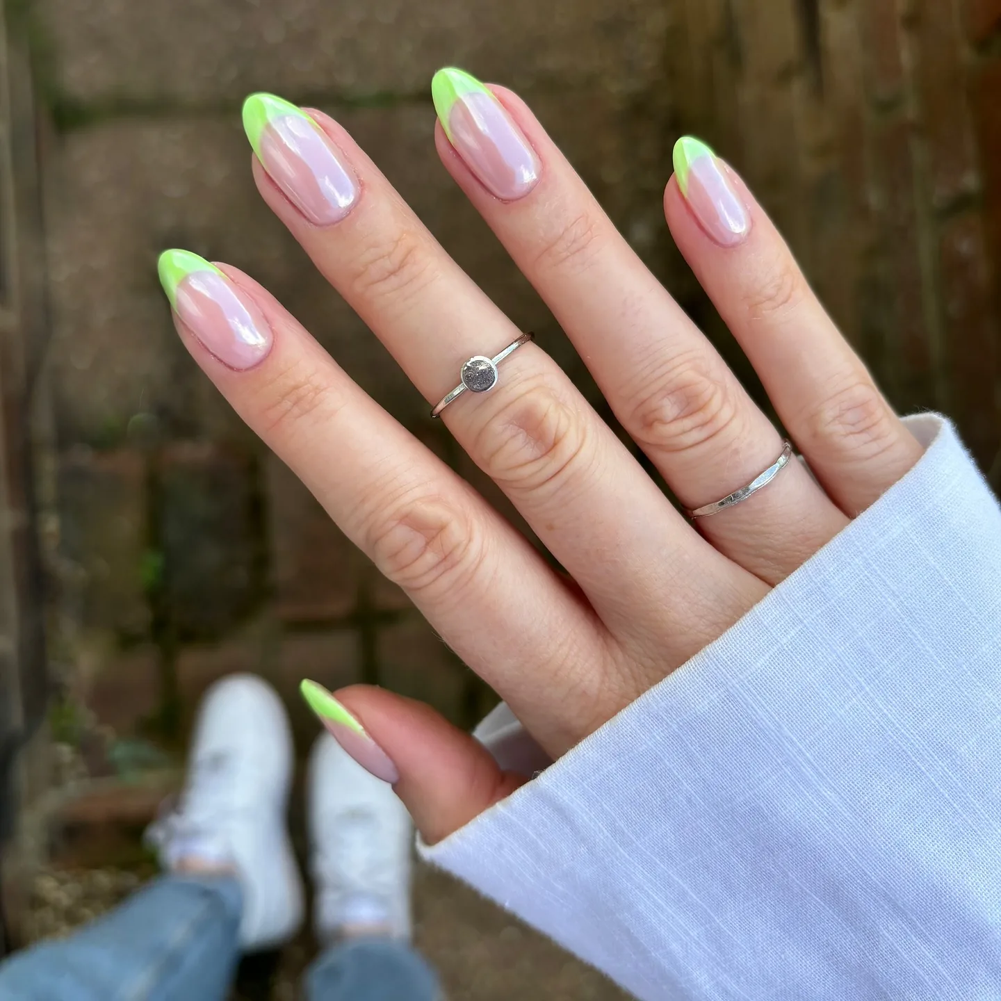 Ongles en amande aux pointes french vert citron sur une base chrome nacrée et glacée.