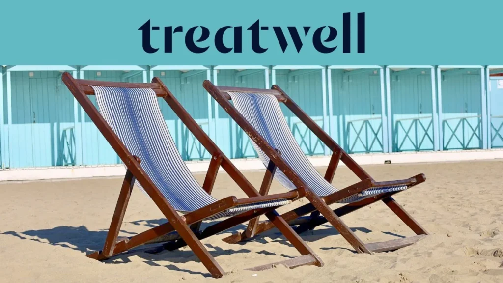 Deux chaises longues en bois rayées sur le sable devant des cabines de plage bleu pastel sur la côte de Versilia