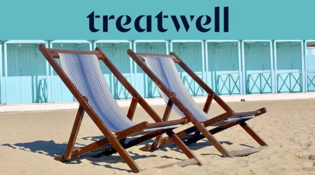 Deux chaises longues en bois rayées sur le sable devant des cabines de plage bleu pastel sur la côte de Versilia