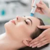 Gros plan d'une femme détendue, les yeux fermés, pendant un soin Hydrafacial dans un institut calme