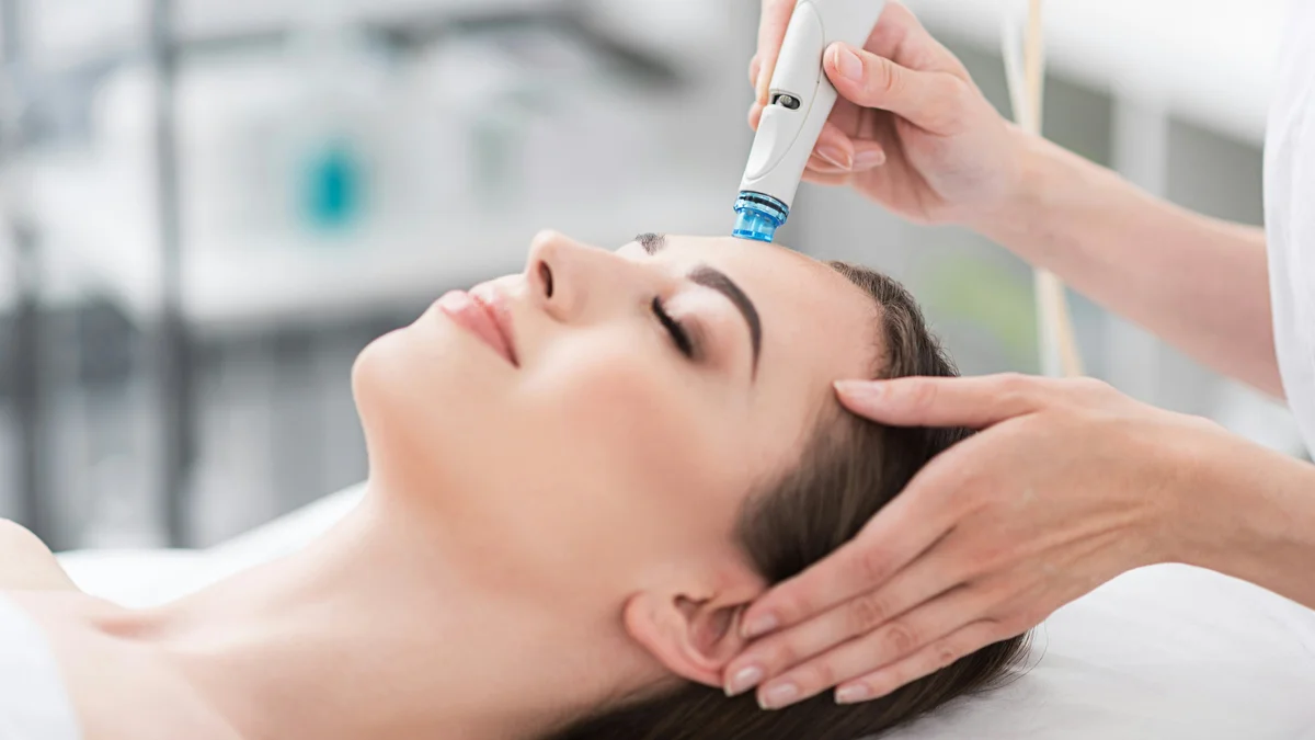 Gros plan d'une femme détendue, les yeux fermés, pendant un soin Hydrafacial dans un institut calme