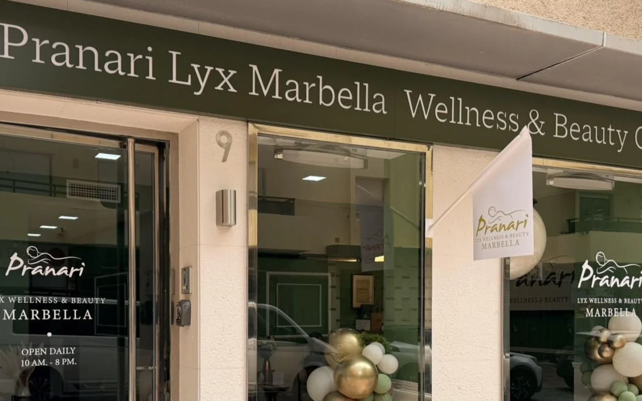 Le local d'Anchan Massage à Marbella, un studio de bien-être et de beauté à la façade verte, avec des ballons blancs et dorés près de l'entrée vitrée.